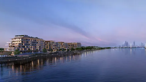 Bashayer Residences: apartment buildings along the water at dusk with the city skyline, developer render
