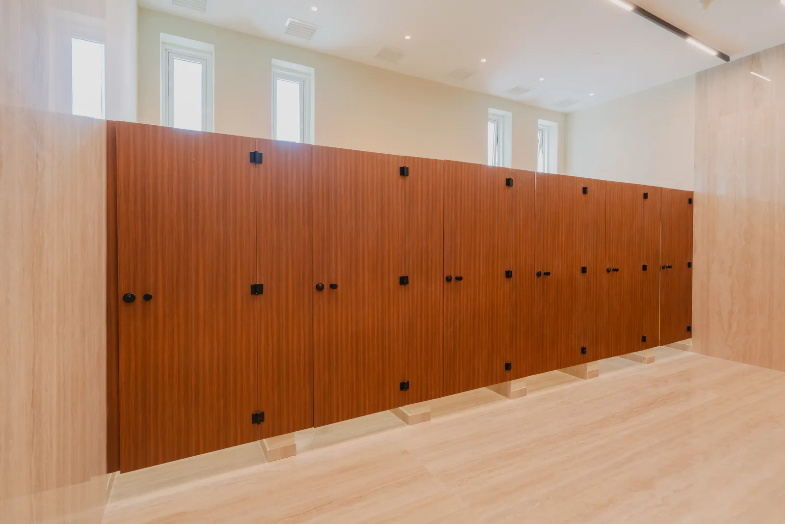 A wall of timber lockers under a row of small windows in the changing room