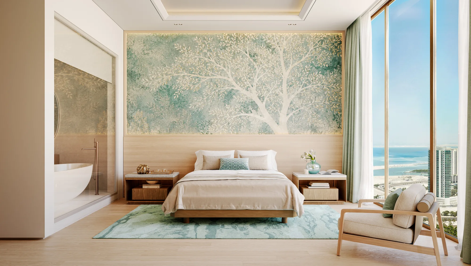 A bedroom with a tree-motif wall and the en-suite bathtub visible behind glass, with sea views