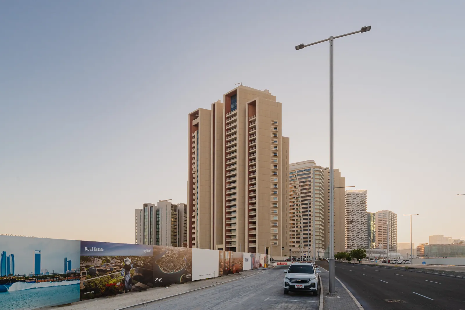 Baheen Tower from street level at dawn, with the road in front and the surrounding Al Reem Island towers