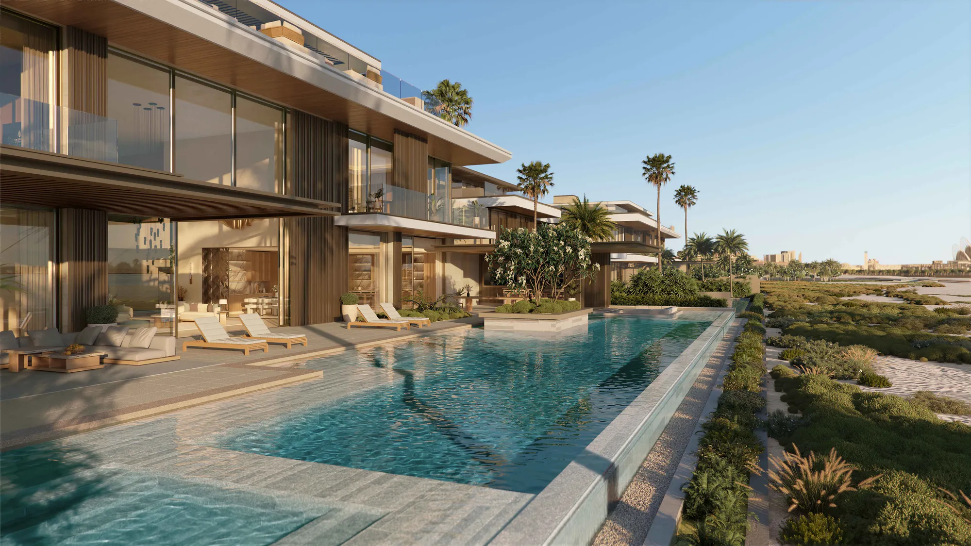 A terrace pool along the villa’s beach side, with dune grasses and the shoreline beyond
