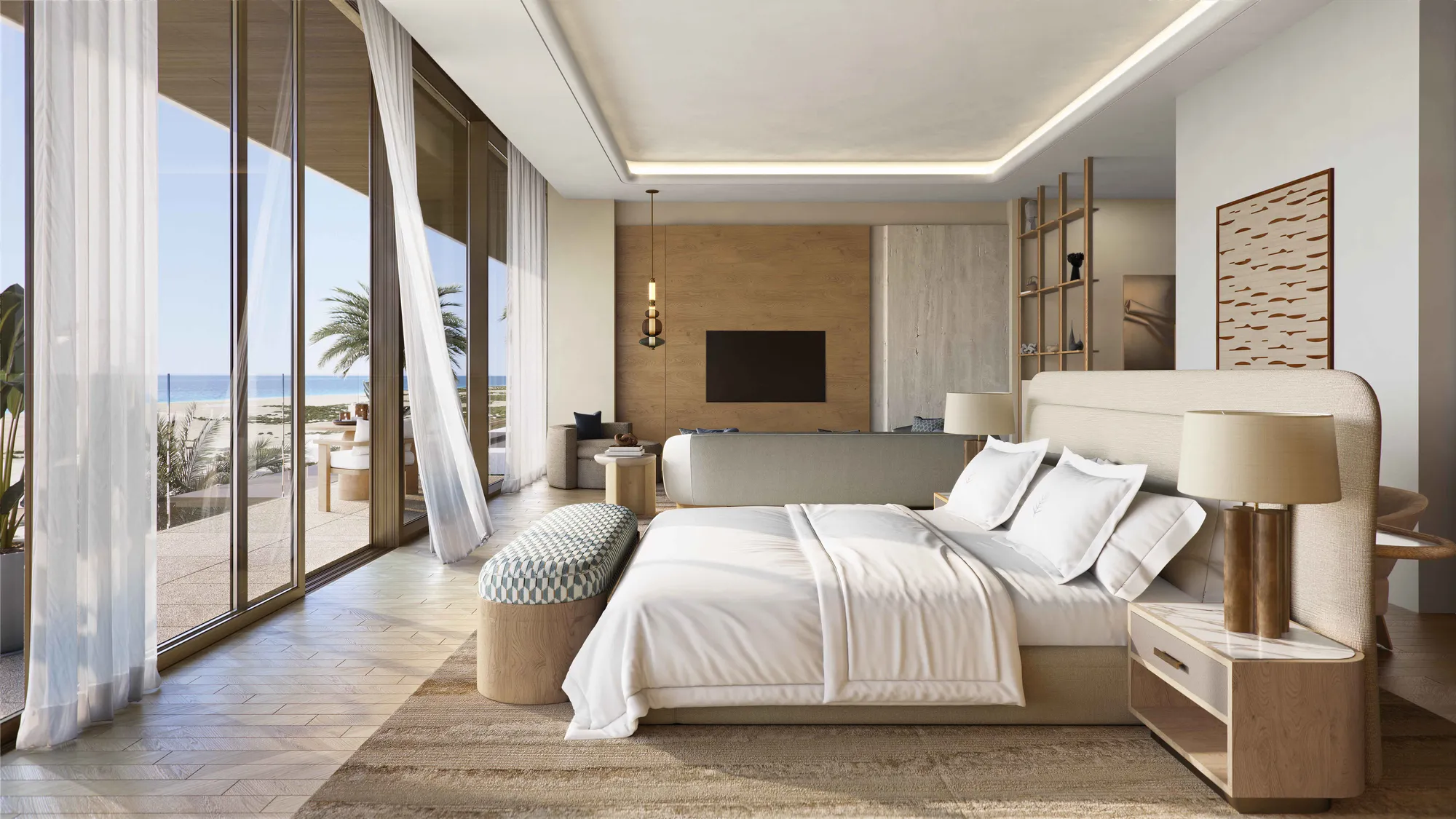 A bedroom opening onto a beach-facing terrace, the sand and sea through the glass