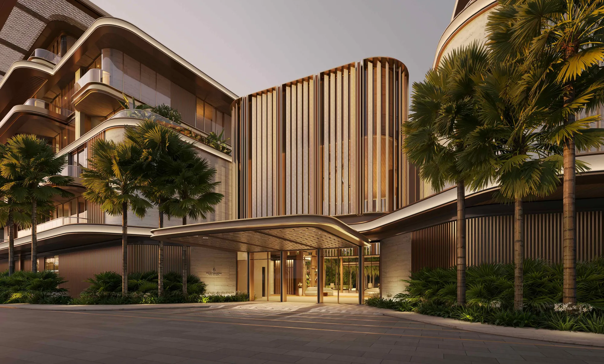The arrival at the suites building at dusk: curved balconies and bronze fins