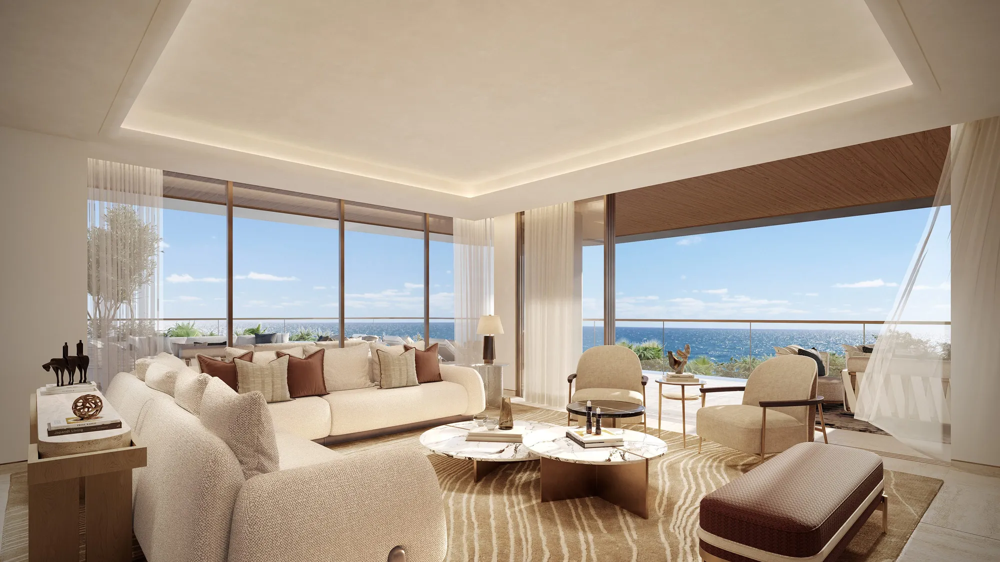 A suite living room: low sofas facing floor-to-ceiling glass, the terrace and the sea beyond
