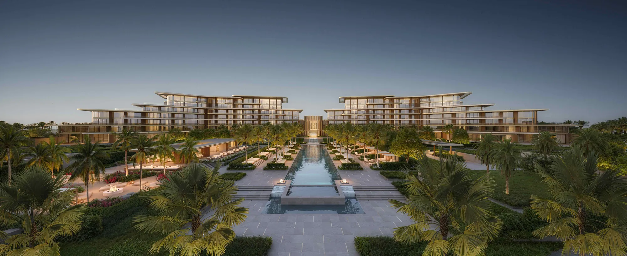 The suites building along the pool axis at dusk