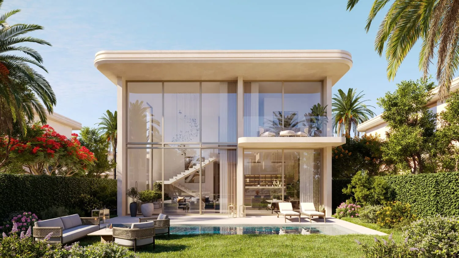 A villa from its garden by day: a two-storey glazed house with a pool, loungers and an outdoor sofa on the lawn